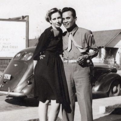 A black and white photograph of Hazel Bickel and Bob Mariano’s on their first date. They are standing in front of a car with Buddy the dog, Bobby Mariano’s Aunt’s dog. The dog was from Oklahoma like Hazel's family. The photograph was taken on Bridge Street in Watsonville.
